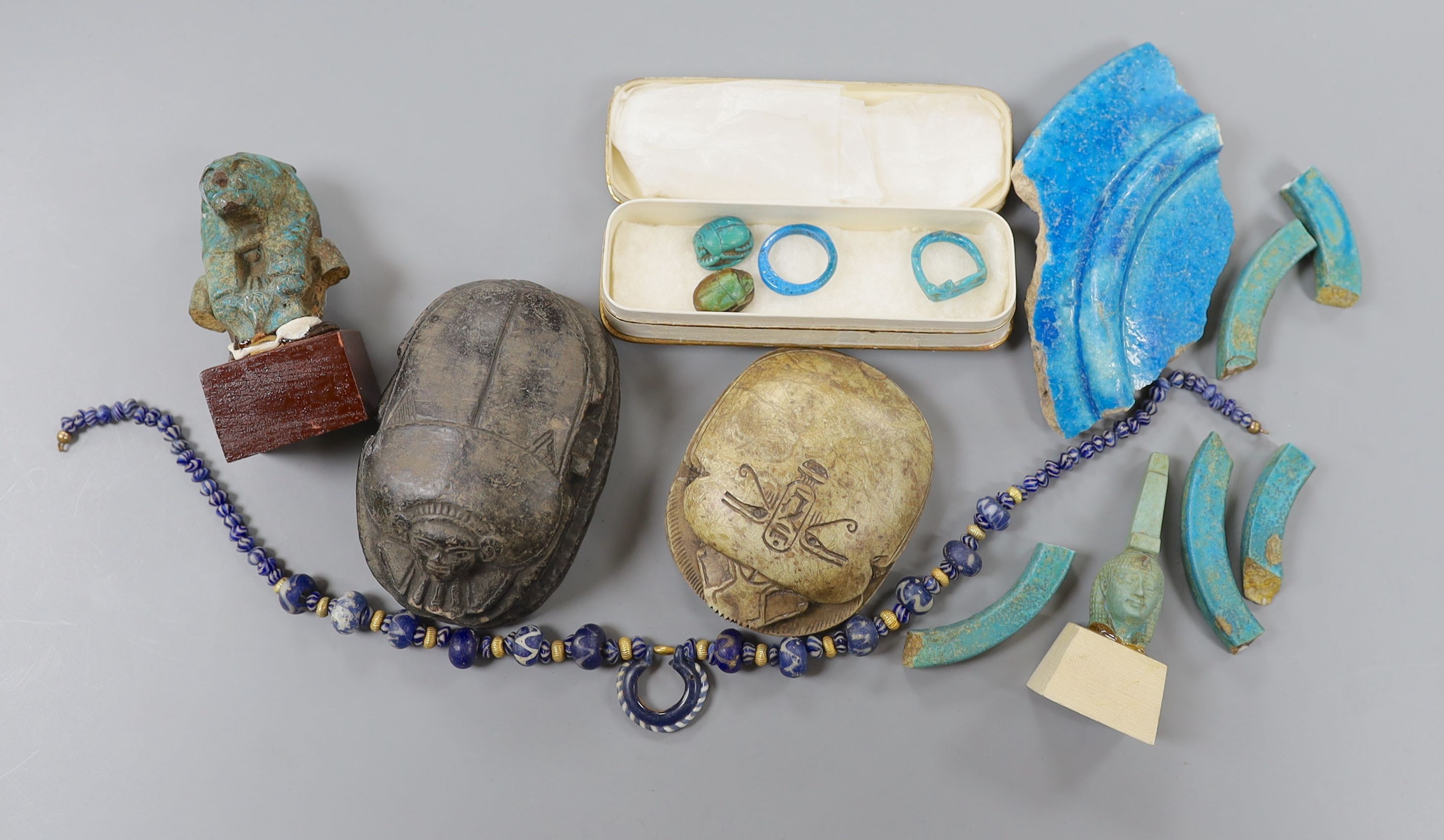 A small collection of Egyptian artefacts including necklace, scarabs, rings and a later scarab, part of the Josephine Dubois collection